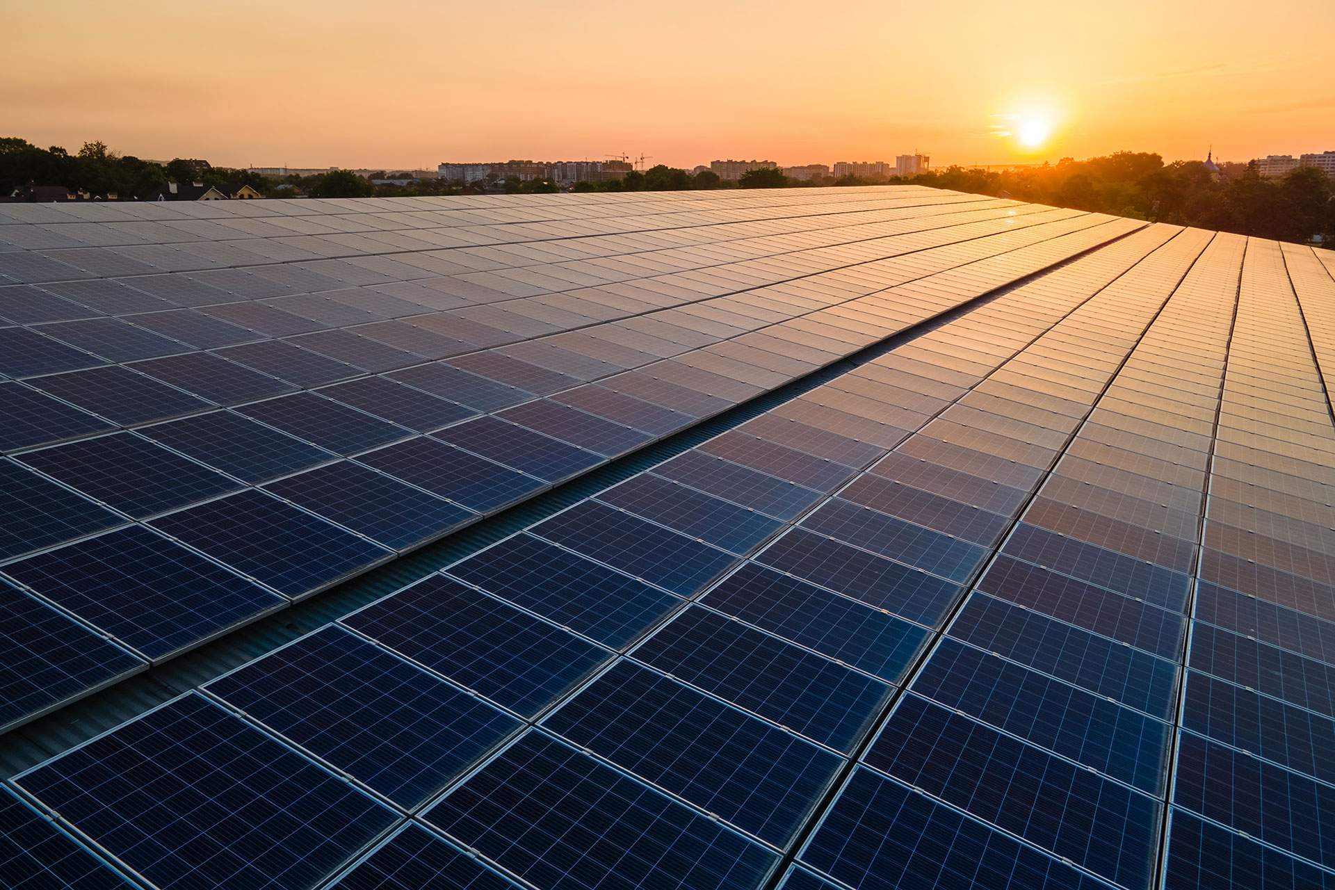 Zonnepanelen op een dak bij zonsondergang