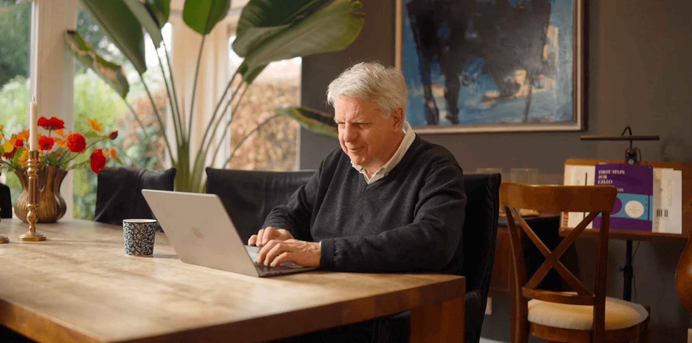 Man vult thuis aan de eettafel op zijn laptop een aanvraag in
