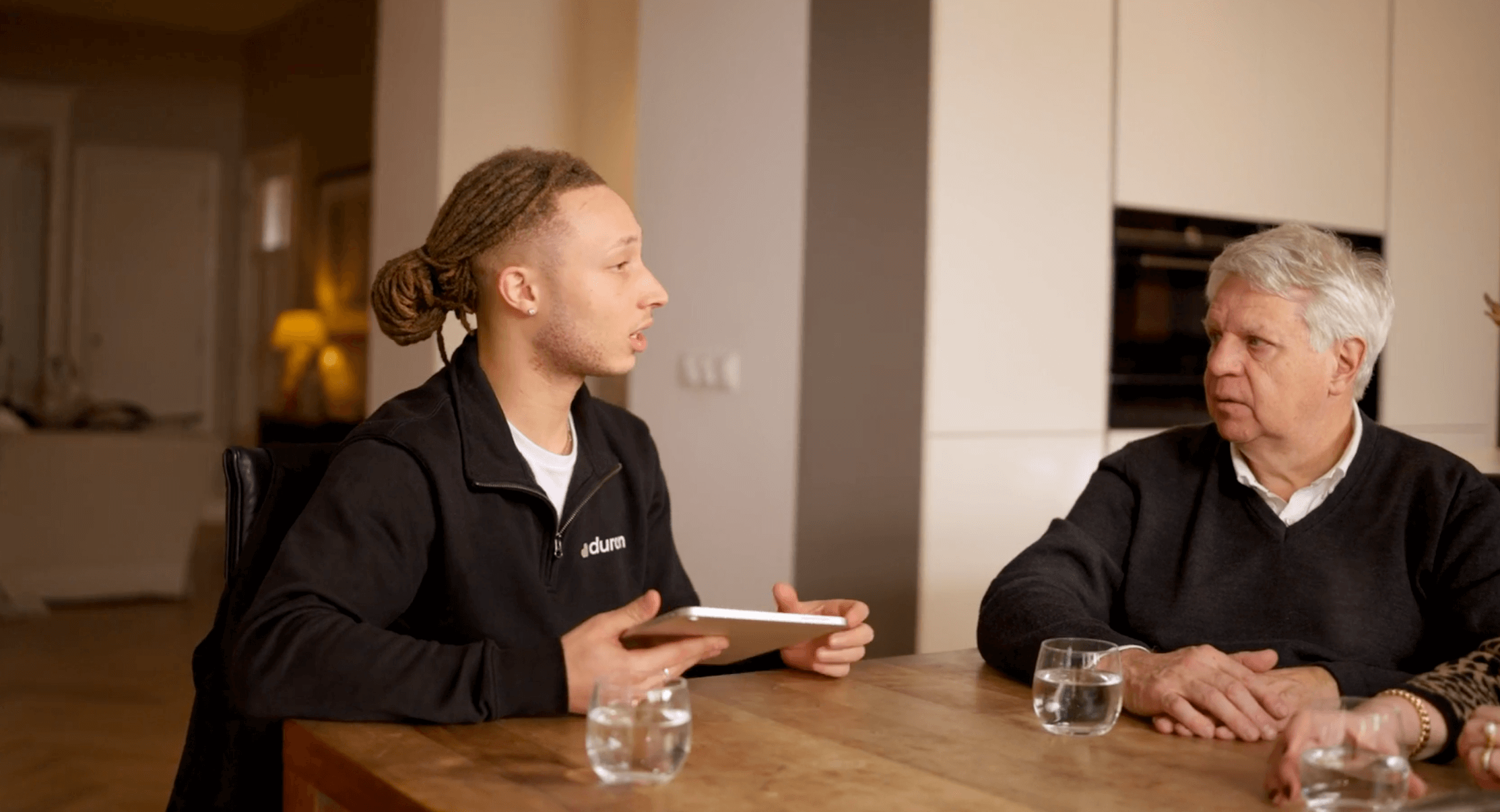 Duron-adviseur met tablet in gesprek met een klant aan de eettafel