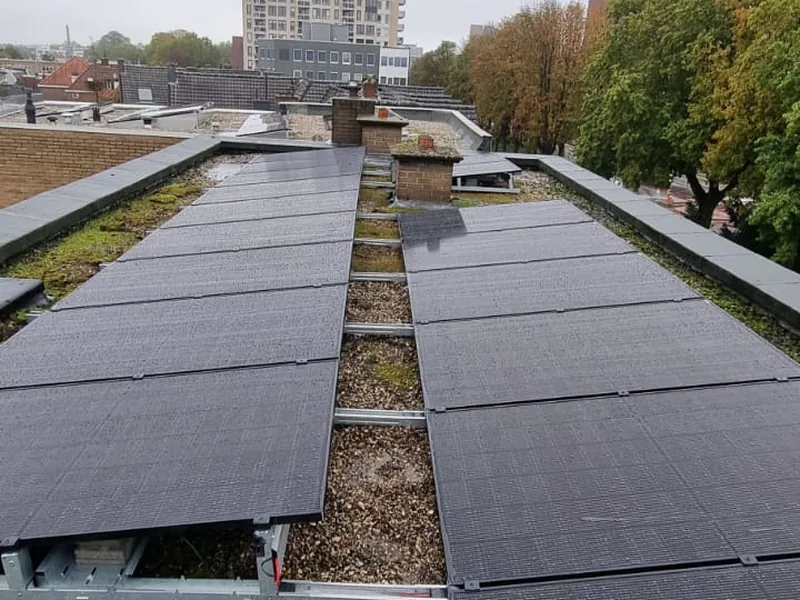 Zonnepanelen in tegenover elkaar liggende rijen op het platte dak van Vitaal Center Smulders in Enschede